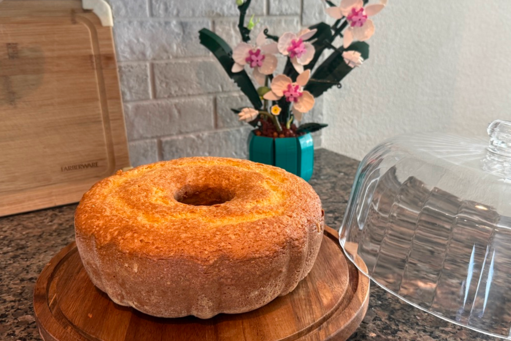 A plate with a Cornmeal Cake with a Flower in the background.