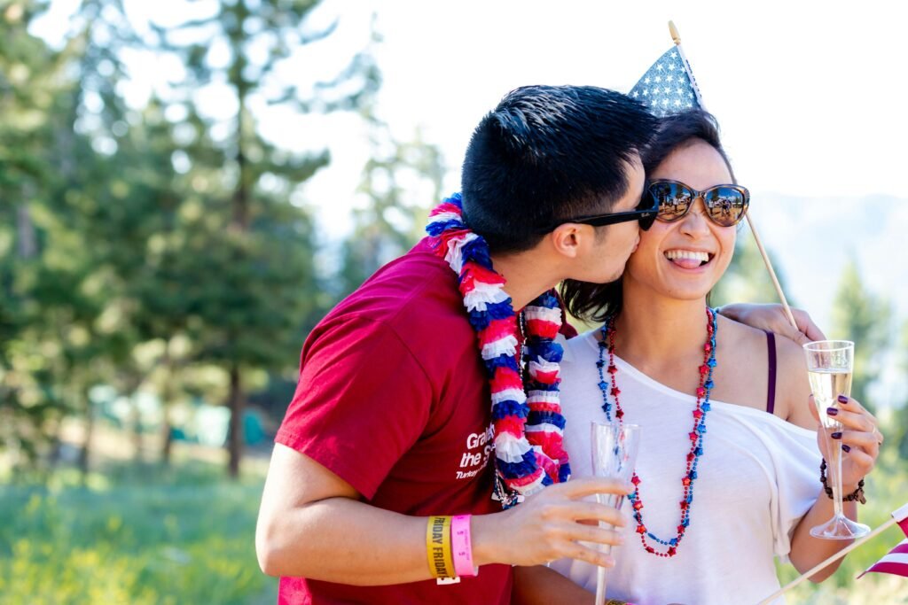 A guy kissing his girlfriend, both wearing celebration clothes.