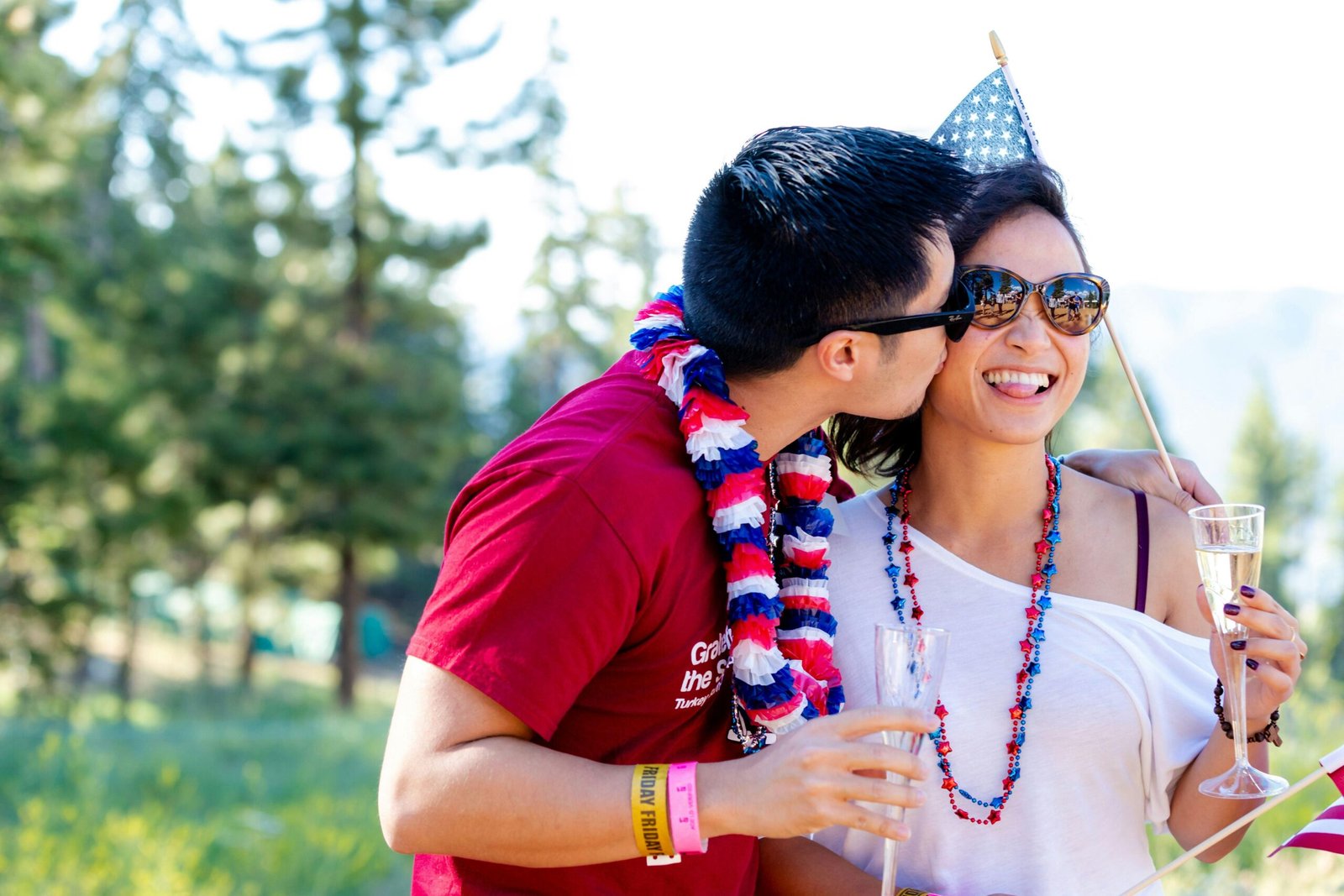 A guy kissing his girlfriend, both wearing celebration clothes.