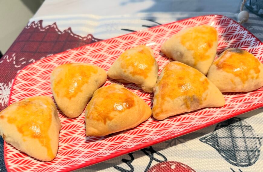 Homemade Brazilian meat esfihas arranged on a red and white plate.