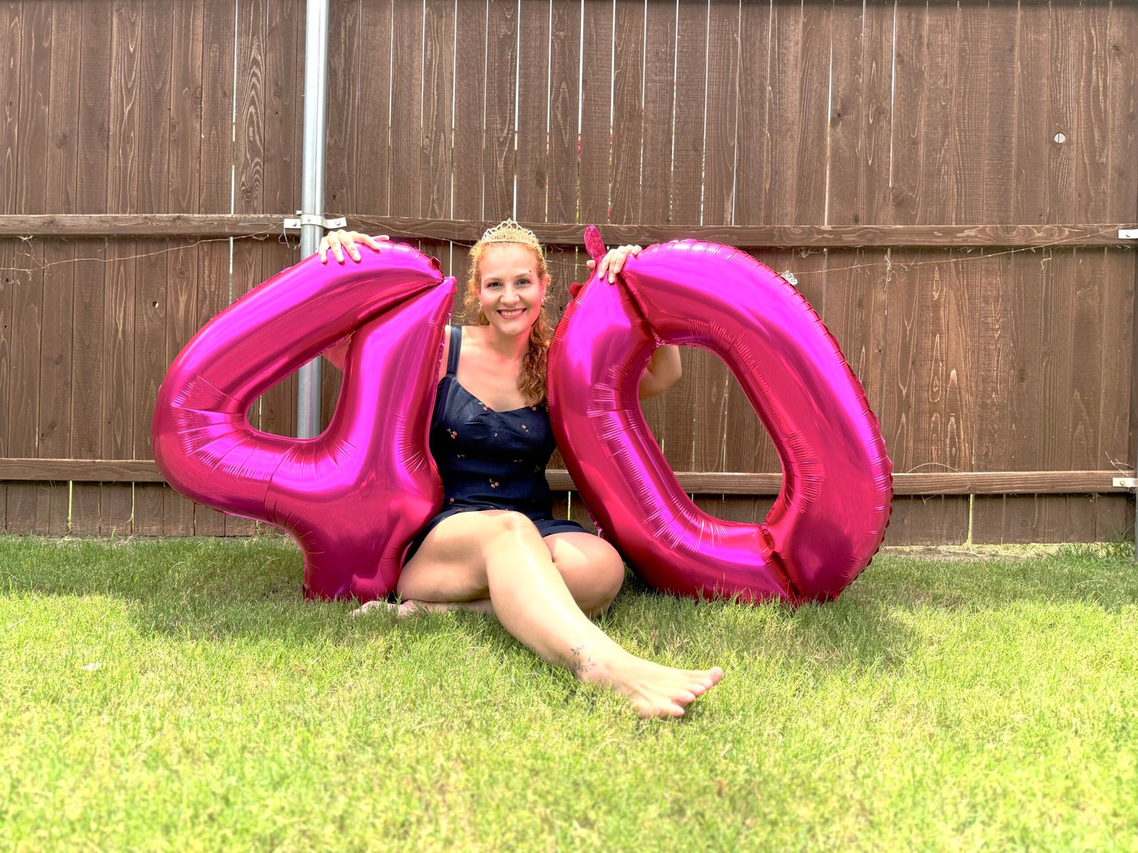 Woman sitting on the grass in yard.