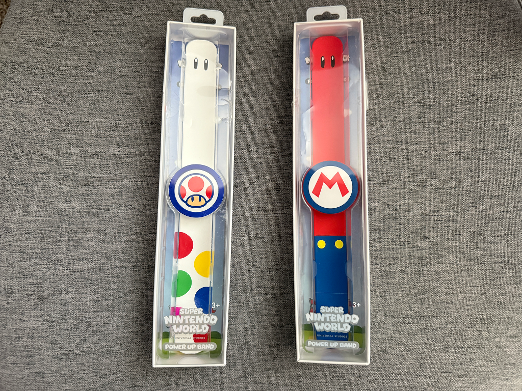 Close-up of Super Nintendo World Power-Up Bands displayed for purchase, themed with characters like Mario, Luigi, and Princess Peach.