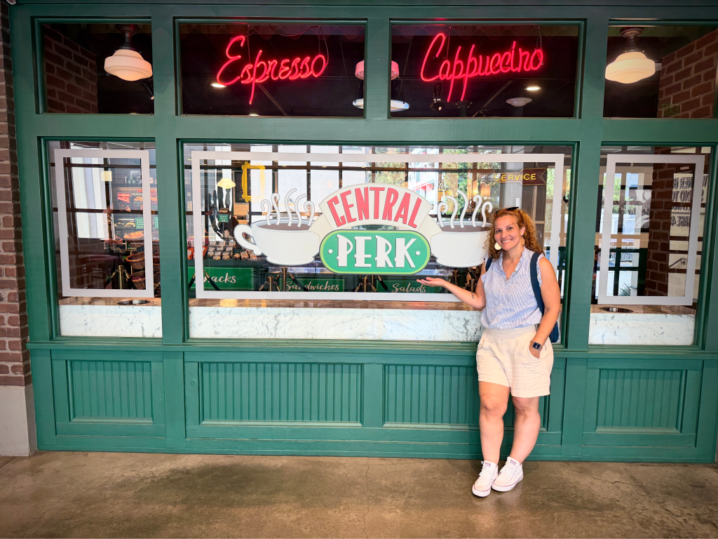 Woman standing in front of the Central Perk wall from the TV show Friends at Warner Bros Tour.