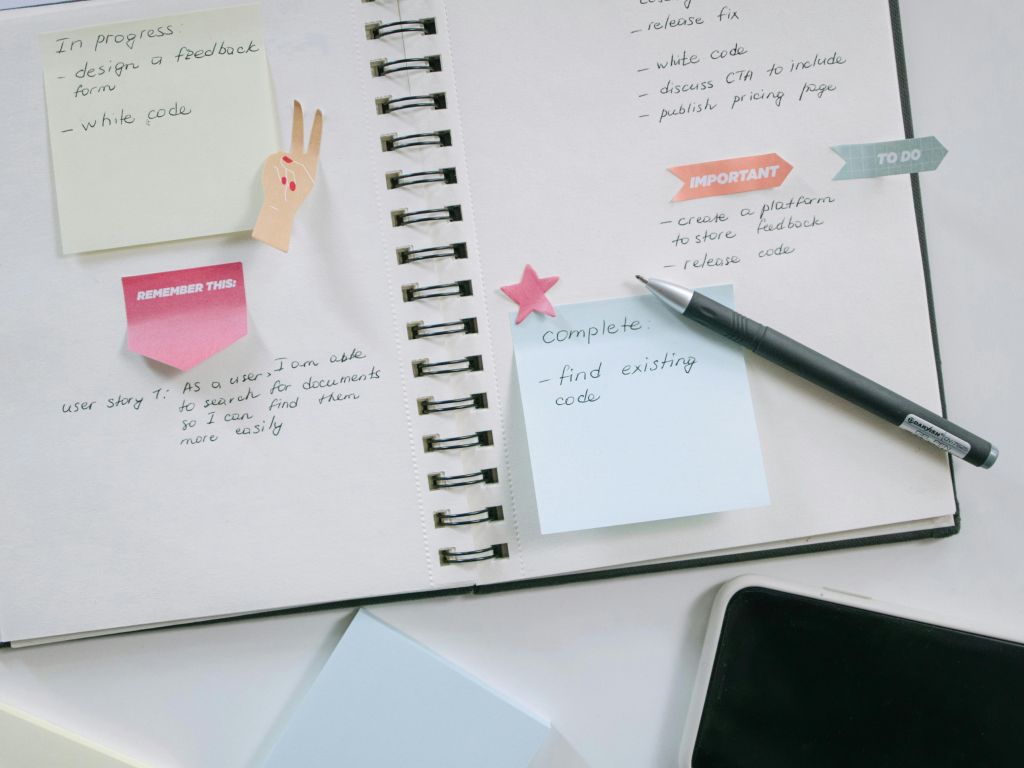 Open planner on a table with two handwritten columns labeled “Important” and “To Do,” a pen and colored tabs