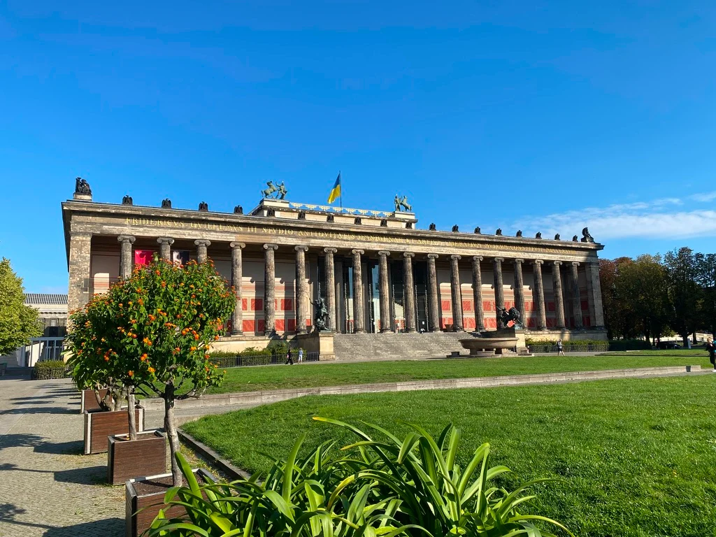 Altes Museum in Berlin with its neoclassical façade and wide staircase under a blue sky.