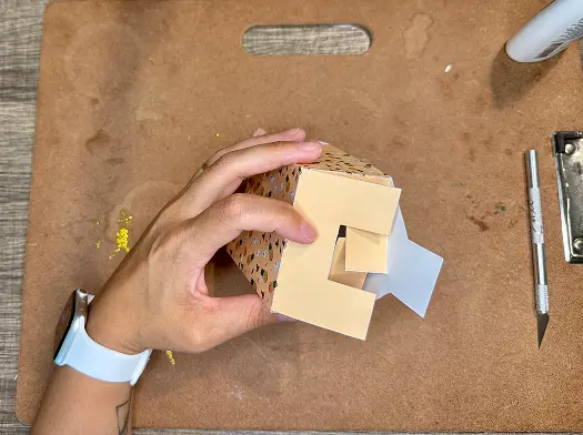 Folding the flaps of Halloween Treat Bags.