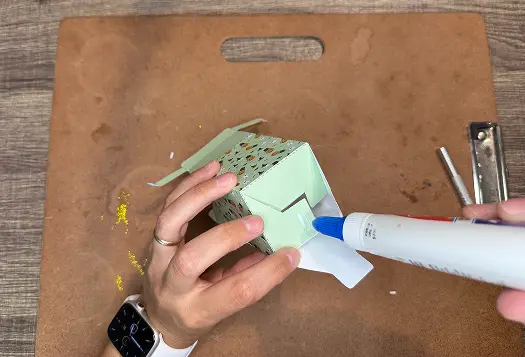 Applying glue on the flag in Halloween Treat Bags