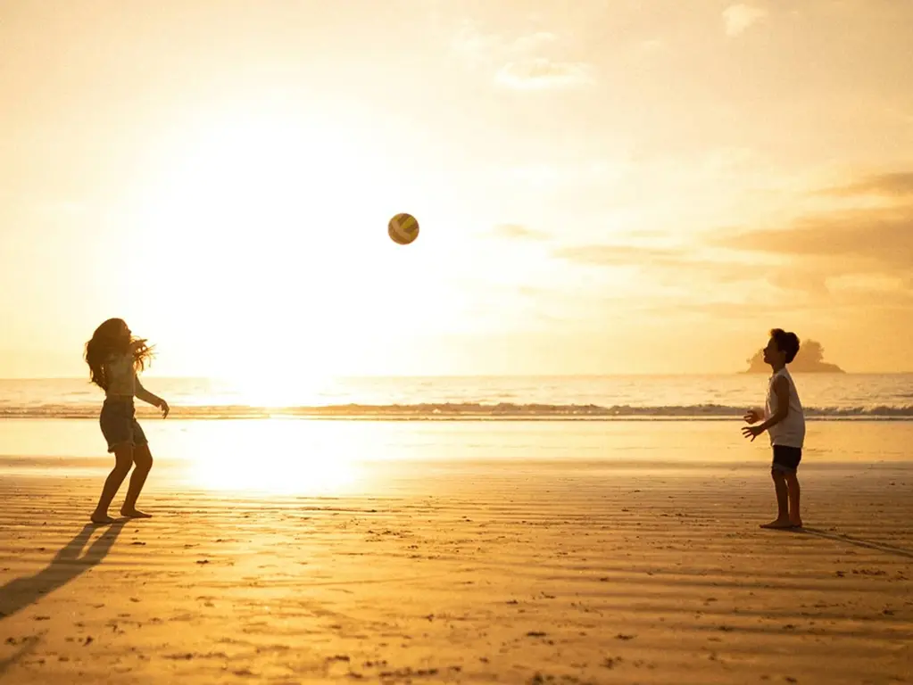 Two kids playing beach volleyball at a family-friendly resort in Brazil