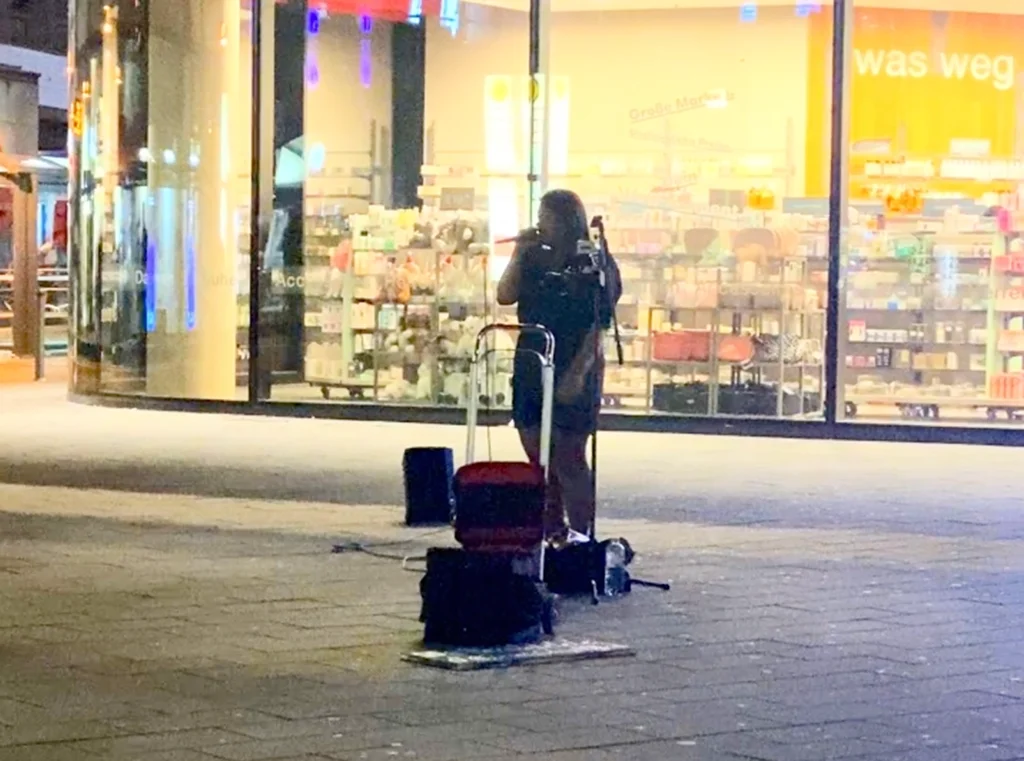 Singer performing on a Berlin street at night.