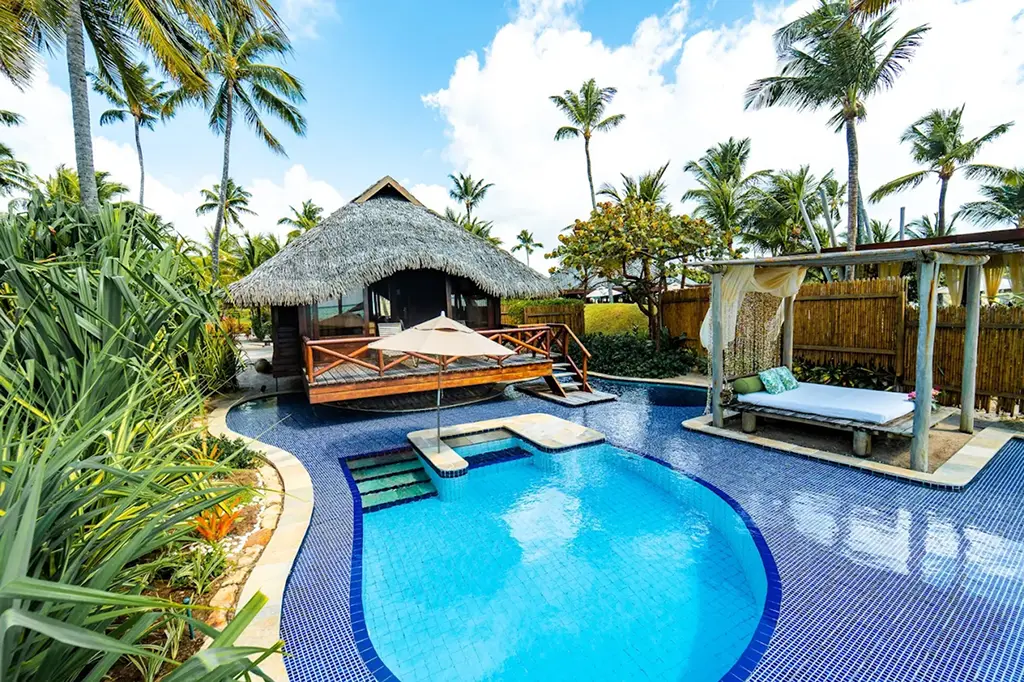Small pool with beach bed and swim-up bar at the resort
