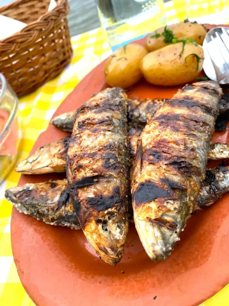 Grilled sardines served on a plate with lemon