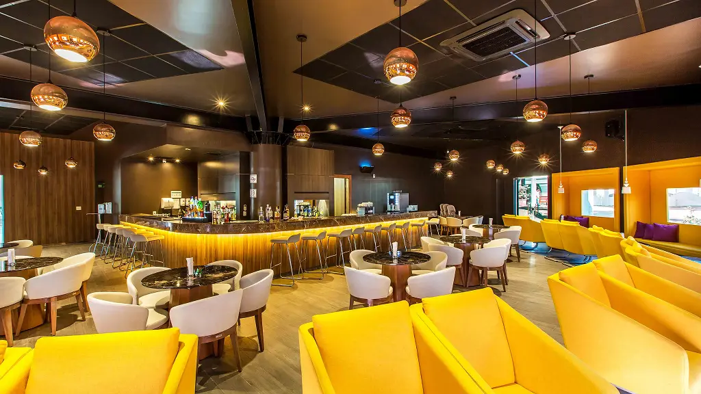 Cozy hotel restaurant with yellow chairs and decorative chandeliers